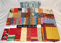 Multicolor patchwork fabric pieces, some with attached brand tags, displayed in a pile showing variety of patterns and colors.