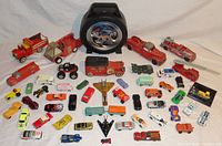 Front view of assortment showing larger fire trucks, case, multiple vintage cars, and smaller diecast vehicles arranged in front