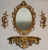 Full set including oval mirror, wall shelf, and pair of candle sconces laid out flat.