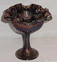 Front side view of the Fenton Persian Medallion carnival glass compote showing the ruffled edge and iridescent finish.
