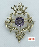 Front view of brooch showing crown motif, central amethyst and pearl accents