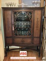 Full front view of walnut china cabinet with fretwork door closed
