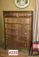 Front view of the highboy dresser in warm wood tone with six drawers and curved sides, showing overall shape and condition.