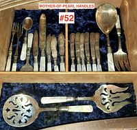 Top drawer view with small forks, spoons, spreader and assorted knives