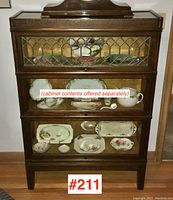 Front view of three-section oak barrister bookcase showing sliding glass doors and leaded glass top panel