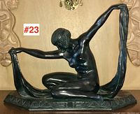 Full front view of the kneeling female figure holding draped scarf