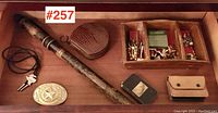 Overview of the drawer showing all assorted vintage items including belt buckle, bolo tie, baton, leather purse, metal box, trays with cufflinks and keys.