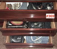 Three open wooden drawers filled with assorted vintage handbags, showing varying styles and materials.