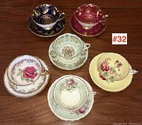 Overview of six Paragon teacup and saucer pairs on wooden surface