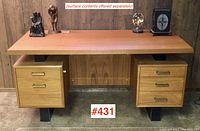 Full front view showing teak top, central privacy panel, drawer pedestals, and black metal feet