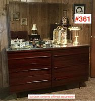 Frontal view of the dresser showing the eight drawers and glass top protector with surface contents removed.