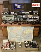 Front view showing multiple receivers, transmitters, microphones, speakers, world map and parts boxes