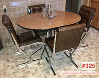 Front-angle view of oval table and four matching chairs on tiled floor.