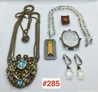 Full view of all six jewellery pieces arranged flat with lot number label