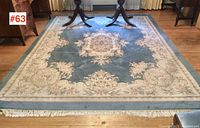 Full view of 8' x 10' rug showing overall field, border and fringe ends with table legs for scale