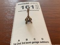 Front view of 10k gold Eiffel Tower charm on measurement card