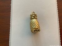 Front view of textured pineapple charm on white paper