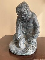 Front view of the large resin carving showing the Inuit hunter bending over fish with detailed textured clothing and facial features.