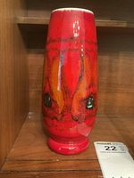 Front view of Mid-Century Modern Poole Pottery vase showing vibrant orange and green pattern with dark accents.