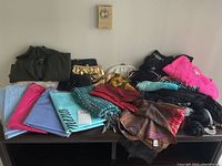 Full overview of all items on table including scarves, sweater, gloves and handbags