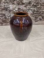 Full view of large brown glazed antique Chinese jar showing overall shape and condition.