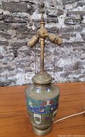 Full view of the antique Chinese lamp base showing cloisonné enamel body and brass fittings.