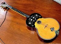 Three-quarter view of entire guitar on wooden surface showing body, neck and headstock