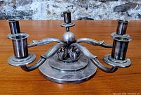 Front view of silver plated candelabra showing five candle holders and central ball base.