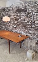 Full view of chrome arc lamp over table with marble base visible