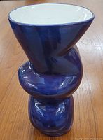 Front view of the twisted blue studio pottery vase showing its unique sculptural form and glossy glaze.