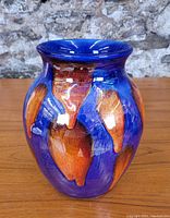 Front view of Poole Pottery vase showing vibrant blue glaze with orange accents.