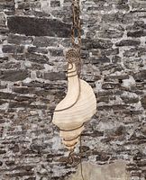 Front profile of hanging conch shell lamp against stone wall