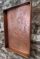 Top-down view showing the interior base of the tray with multiple dents, discolorations, and patina spots.