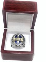 Men's large championship ring with blue enamel and clear stones in a wooden display box