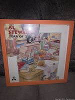 Framed Al Stewart Year of the Cat album cover with LP inside orange frame.