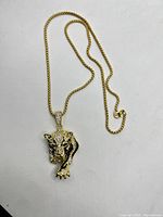 Full view of the 24 inch gold toned chain with jaguar head pendant lying flat.