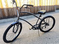 Side view of the full Hyper Commute men's cruiser bike showing frame shape, pedals, chain, tires, seat and handlebars.