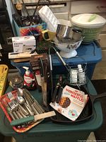 Overview of lot items including flatware, colanders, electric iron, container, and waffle iron