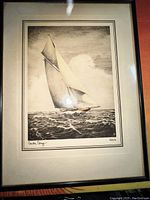 Framed vintage sailboat etching signed by Andre Uray, showing detailed linework of a yacht on the water.