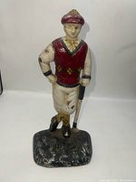 Front view of the vintage cast iron golfer doorstop showing the painted details and textured base.