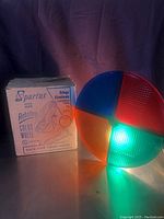 Vintage Spartus rotating color wheel lit up, showing red, green, blue, and orange color sections with original box.