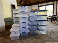 Stack of approximately 30 Sterlite clear plastic storage boxes with lids, arranged in multiple columns, showcasing different sizes and translucent plastic nature.