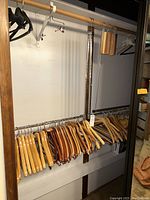 Closet rod doublers installed with wooden hangers on two levels in a closet