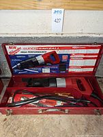 Milwaukee Super Sawzall reciprocating saw inside open red metal case with printed instructions inside lid and several packaging saw blades.