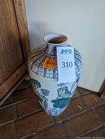 Front angled view of tall ceramic vase showing off water lily and lotus motif with blue, green, and pink colors on white background.
