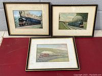 Three framed prints arranged on a surface showing historical steam locomotives by O. S. Nock with distinctive aged mats and black and gold frames.