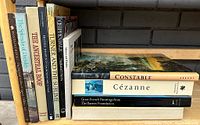 Photo of eleven art books arranged on a shelf showing titles including Constable, Cézanne, Chippendale, Turner and others, illustrating the content and condition of the lot.