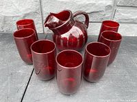 Photo of the ball pitcher and 7 tumblers showing the set and deep ruby red color
