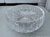 Front angle photo of the heavy lead crystal cut bowl showing detailed diamond and starburst patterns and its clear transparency.