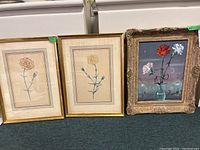 Three framed botanical pieces: two carnation prints flanking an oil painting